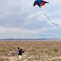 Students fly a kite in the desert.